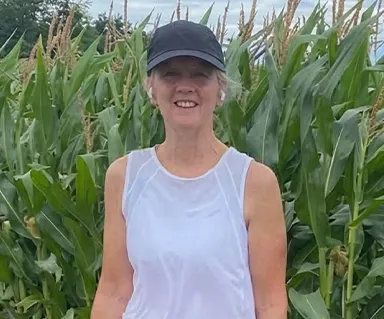 Lynne Pulenzas standing in a corn field before a walk/run for ALS