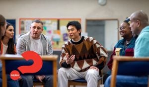 A mixed aged group of people gather in a small group setting